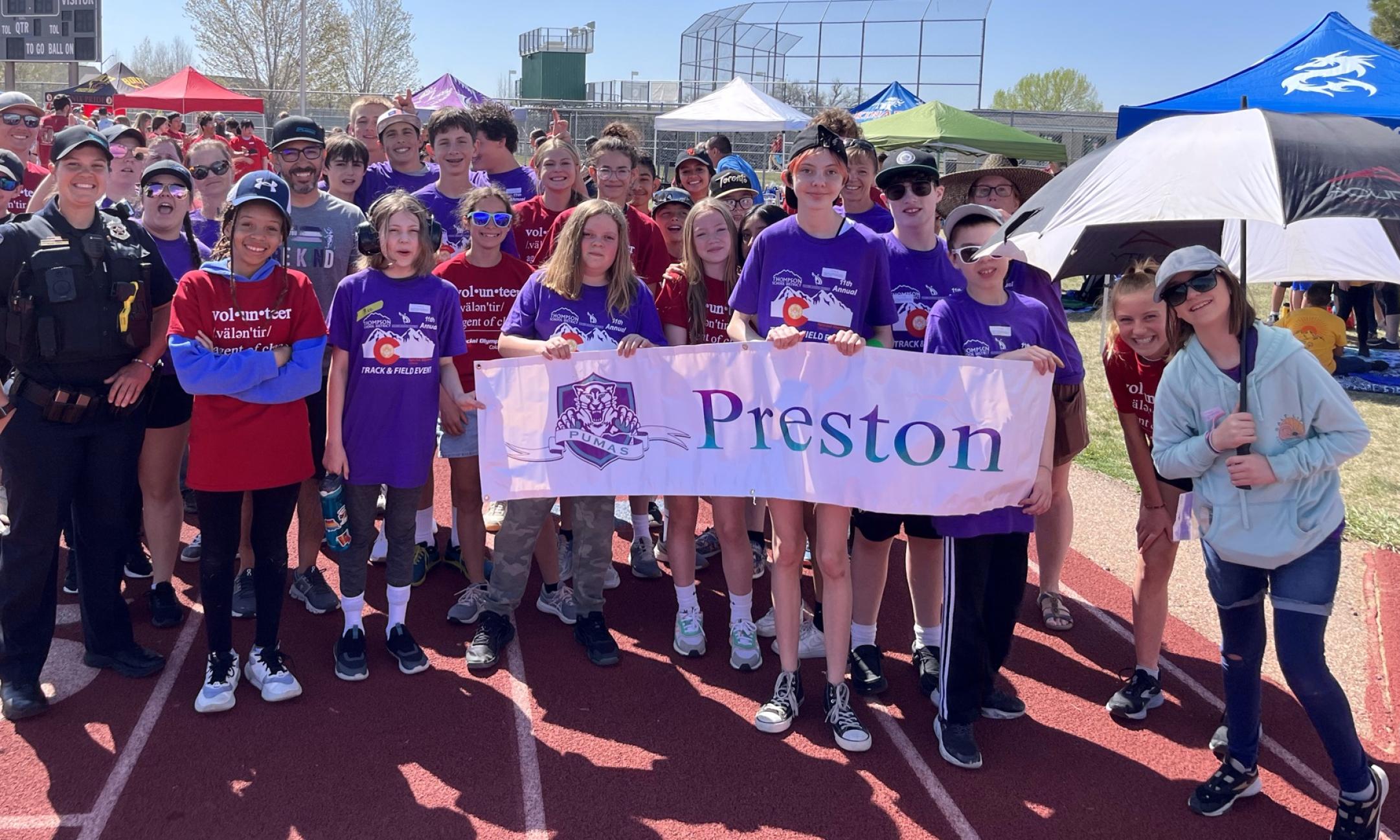 students from 2022-2023  holding preston sign at the starting line of the special olympics